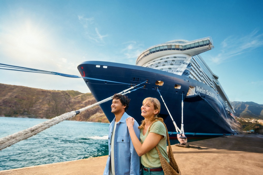 Paar genießt einen besonderen Moment vor einem Mein Schiff Wohlfühlschiff